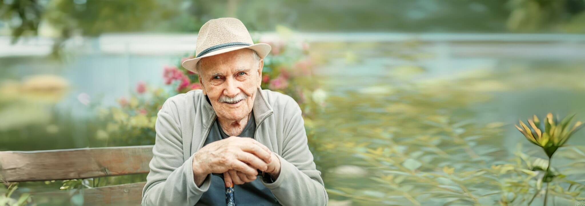 Portrait of a smiling and confident senior 87 years old cute in a hat with a mustache. Happy active old age.