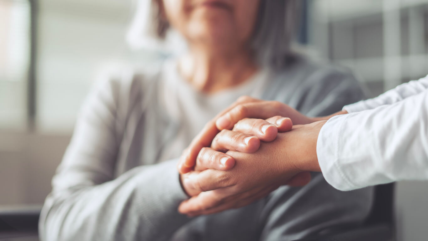 Caregiver holding hands with senior resident, representing memory care in Granada Hills at Royal Garden Board & Care